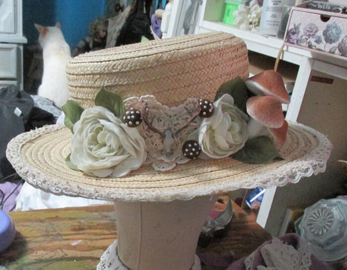 A boater hat trimmed with lace, mushrooms, and a deer's skull in the Mori Girl style.
